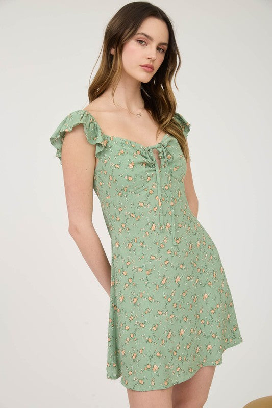 Woman wearing a green floral dress against a white background