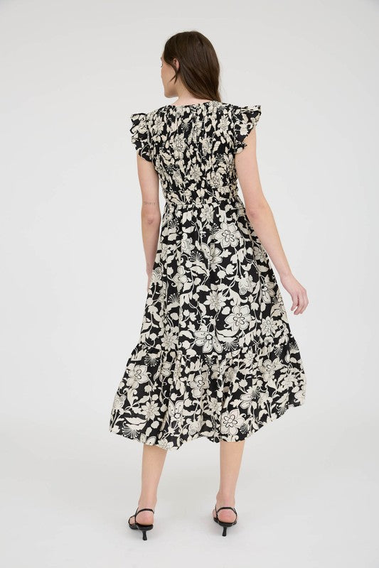 Woman wearing a black and white floral dress on a white background